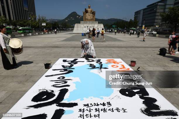 South Korean calligraphist Yeo Tae-myong writes calligraphy on the unification flag to celebrate the upcoming inter-Korean summit on September 17,...