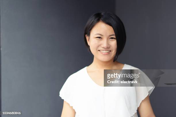 portrait of smiling young woman - 若い女性 日本人 顔 ストックフォトと画像