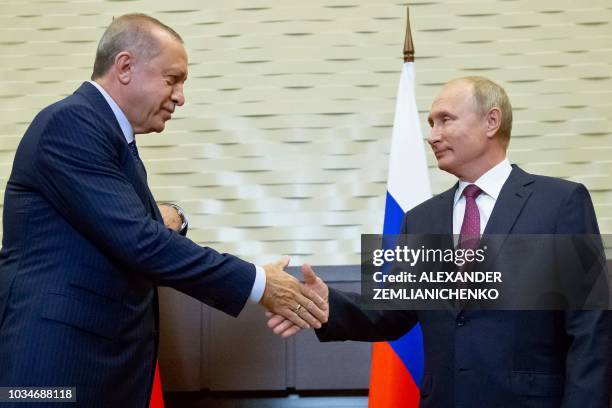 Russian President Vladimir Putin shakes hands with Turkish President Recep Tayyip Erdogan during their meeting in the Bocharov Ruchei residence in...