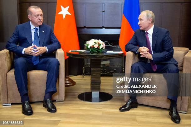 Russian President Vladimir Putin talks to Turkish President Recep Tayyip Erdogan during their meeting in the Bocharov Ruchei residence in the Black...