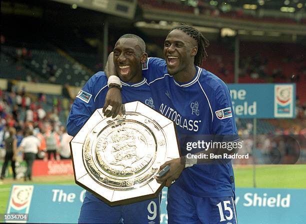 Jimmy Hasselbaink and Mario Melchiot of Chelsea lift the trophy after winning the One 2 One FA Charity Shield match against Manchester United at...