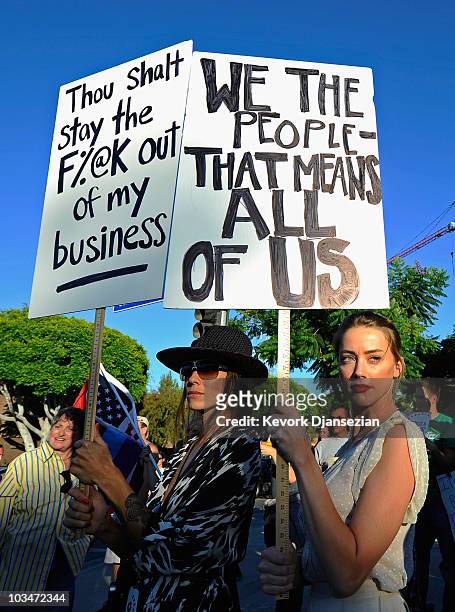 Actress Amber Heard holds a protest sign with her girlfriend Tasya Van Ree during a same-sex marriage advocates demonstration against the stay...