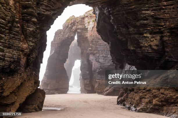 natural rock arches on cathedrals beach in low tide, spain - catedral imagens e fotografias de stock