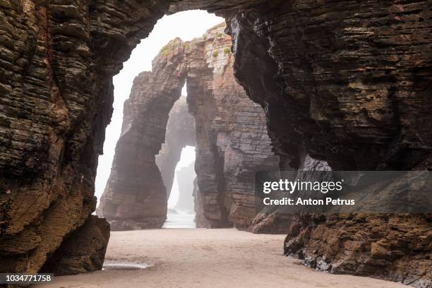 natural rock arches on cathedrals beach in low tide, spain - erosion 個照片及圖片檔