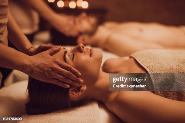 young couple having relaxing head massage at beauty spa. - head massage stock pictures, royalty-free photos & images