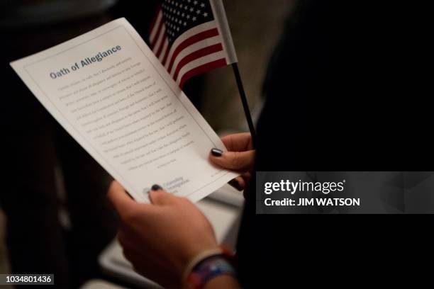 Woman holds the Oath of Allegiance as 31 new citizens from 25 nations are sworn in as new citizens during a naturalization ceremony as part of a...