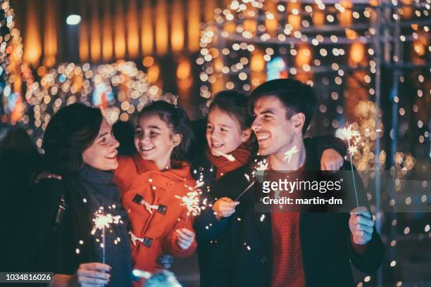 glückliche familie feiern weihnachten und neujahr - sparkler stock-fotos und bilder