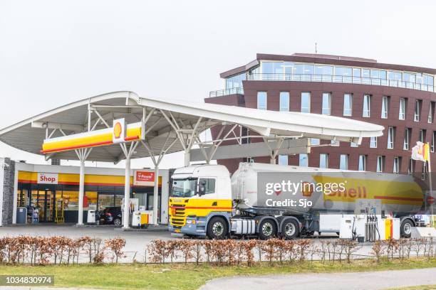 shell fuel delivery trucks supplying a gas station with fuel - shell fuel truck stock pictures, royalty-free photos & images