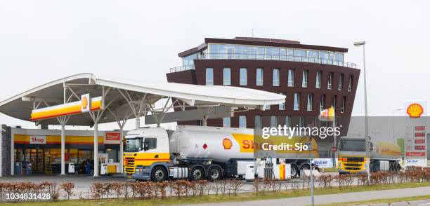 shell fuel delivery trucks supplying a gas station with fuel - diesel trucks stock pictures, royalty-free photos & images