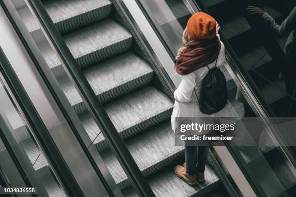 frau auf der rolltreppe - flughafen wien stock-fotos und bilder