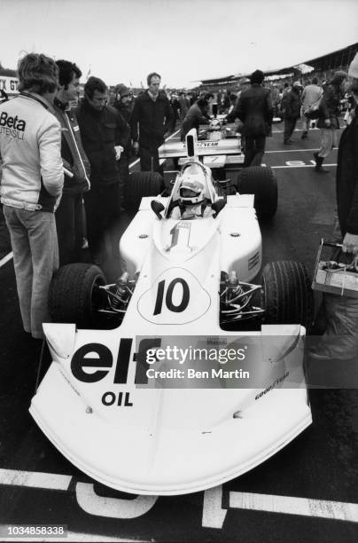 Lella Lombardi in her March Formula 1 on the starting grid at Brands Hatch with Max Mosley and Robin Herd prior to start of race, March 27, 1975.