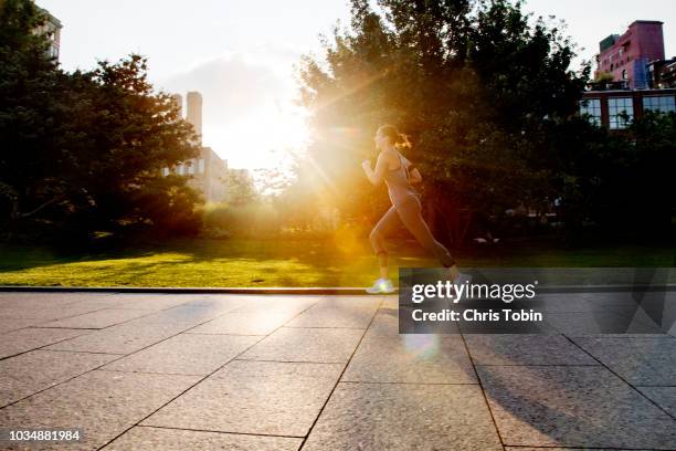 young woman running in park with morning sunlight - runner sunrise stock pictures, royalty-free photos & images