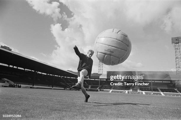 Scottish professional footballer and forward with Manchester United, Denis Law pictured in training on the pitch at the club's Old Trafford ground in...