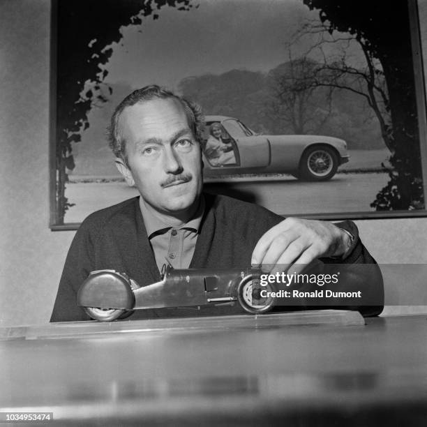 British engineer, designer and founder of Lotus Cars, Colin Chapman posed with a scale model of the Lotus Mk6, the first car to be made with the...