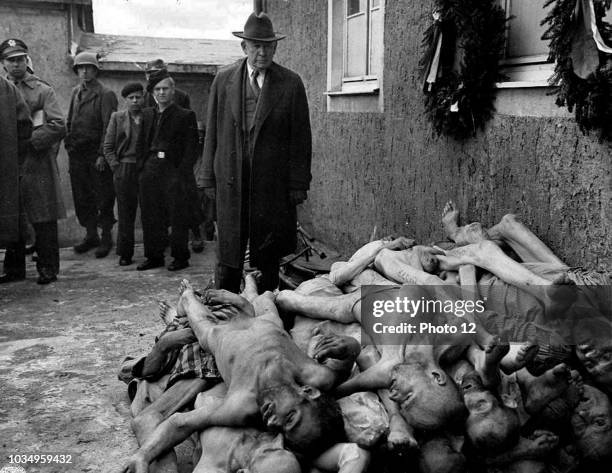 Kentucky Senator Alben W. Barkley visting a German concentration camp. The photo shows the Senator stood infront of a pile of dead bodies at...