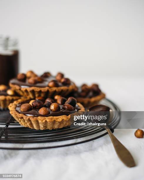 tartlets with nuts and chocolate - tart dessert stock pictures, royalty-free photos & images