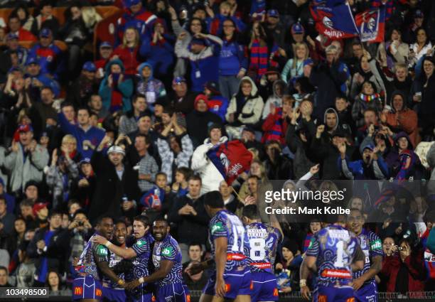 Cooper Vuna of the Knights is congratulated by his team mates after scoring a try during the round 24 NRL match between the Newcastle Knights and the...