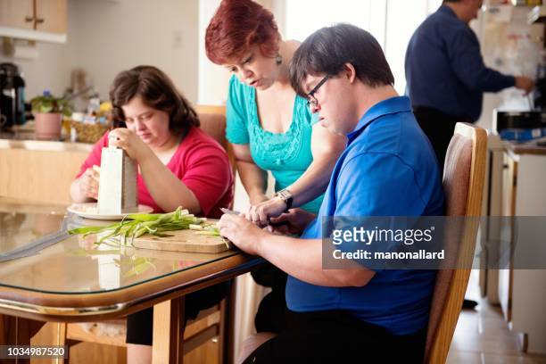 echtpaar met syndroom van down leren koken snijden groenten - verstandelijk gehandicapt stockfoto's en -beelden