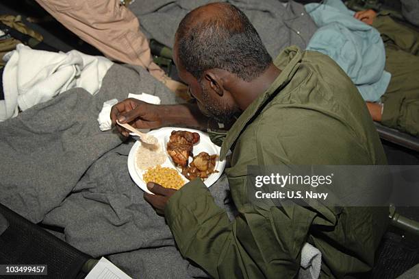 In this handout from the U.S. Navy, a mariner that was rescued in the Arabian Sea after his vessel was engulfed in flames is provided food and...