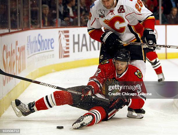 Chicago Blackhawks' Kris Versteeg draws a penalty on Calgary Flames' Robyn Regehr in first period action at the United Center in Chicago, Illinois,...