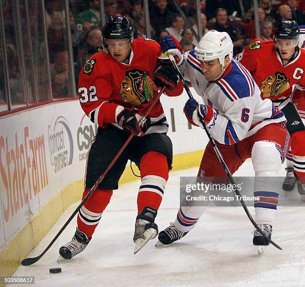 Chicago Blackhawks Kris Versteeg fights for possession of the puck with New York Rangers Wade Redden during first-period action at the United Center,...