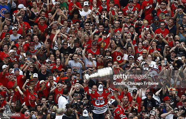 The Chicago Blackhawks' Patrick Kane hoists the Stanley Cup aloft for the crowds during the Stanley Cup victory parade and celebration in Chicago,...