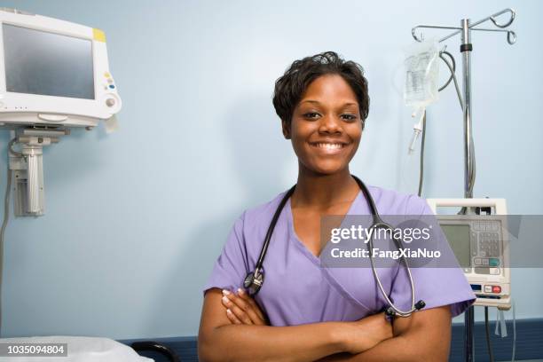 african female nurse smiling in hospital room - pediatric intensive care unit stock pictures, royalty-free photos & images