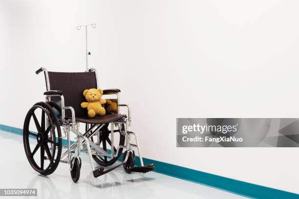 silla de ruedas con oso de peluche en pasillo de hospital - tienda de regalos fotografías e imágenes de stock