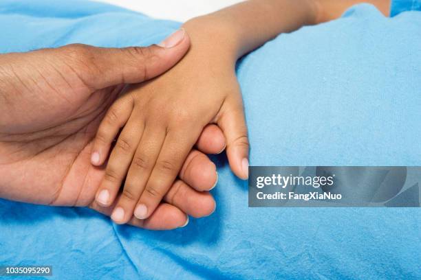 close up of african boy holding parent's hand - children's hospital stock pictures, royalty-free photos & images