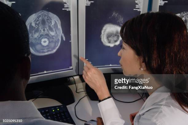 hispanic female doctor pointing at brain scans - diagnostic aid stock pictures, royalty-free photos & images