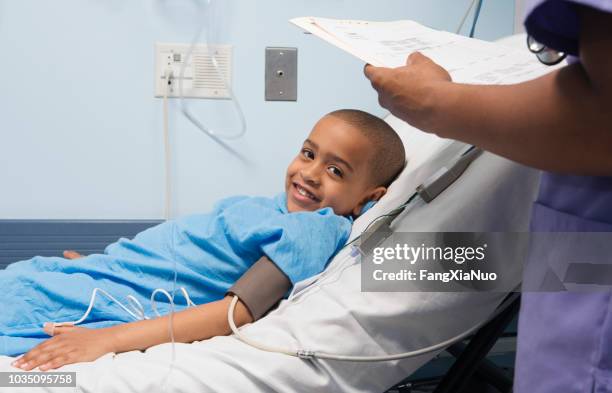 african boy smiling in hospital bed - pediatric intensive care unit stock pictures, royalty-free photos & images