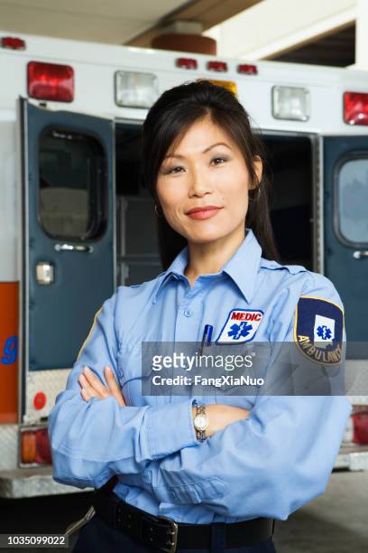portrait of asian female paramedic in front of ambulance - paramedic stock pictures, royalty-free photos & images