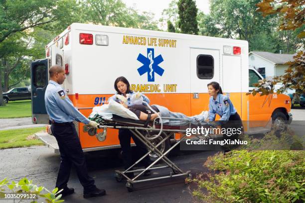 救急隊員が救急車に女性を入れて - 救急救命士 ストックフォトと画像