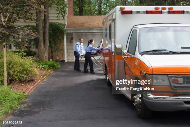 paramedics putting person into ambulance - stretcher stock pictures, royalty-free photos & images