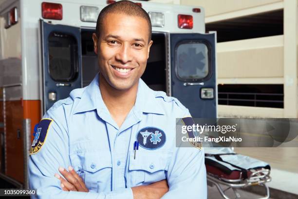 retrato de paramédico africano macho delante de ambulancia - técnicos-en-emergencias-médicas fotografías e imágenes de stock