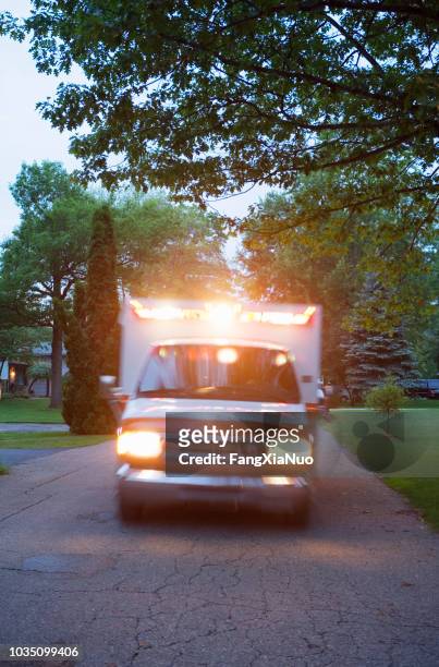 ambulance with lights on in residential area - ambulance lights stock pictures, royalty-free photos & images