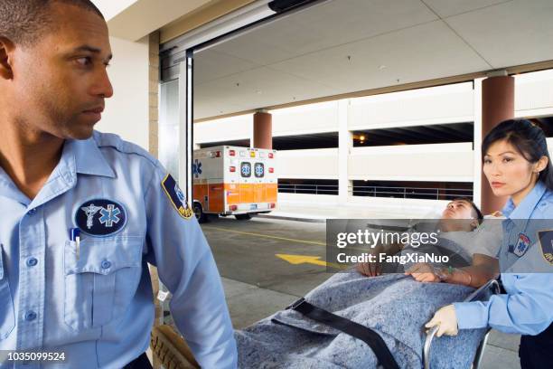 paramedics wheeling man on gurney - ambulance arrival stock pictures, royalty-free photos & images