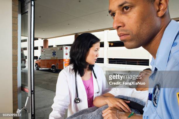 paramedic and doctor wheeling man on gurney - accident hospital stock pictures, royalty-free photos & images