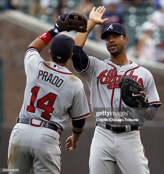 Newly-acquired Derrek Lee, right, celebrates the Atlanta Braves' 5-3 win with Martin Prado at Wrigley Field in Chicago, Illinois, on Friday, August...