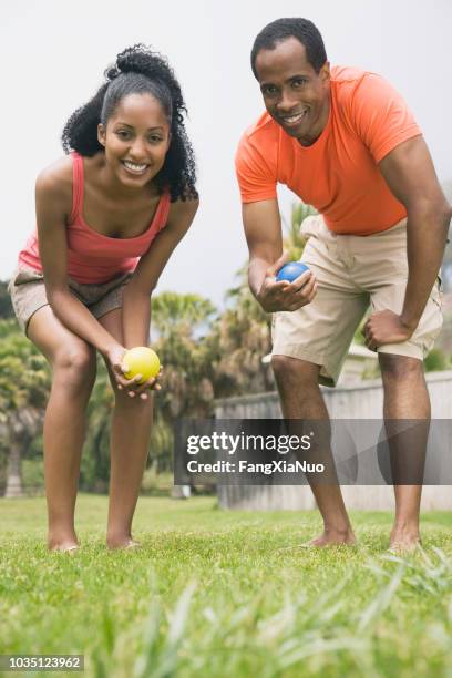 african couple playing bocci ball - bocce ball stock pictures, royalty-free photos & images