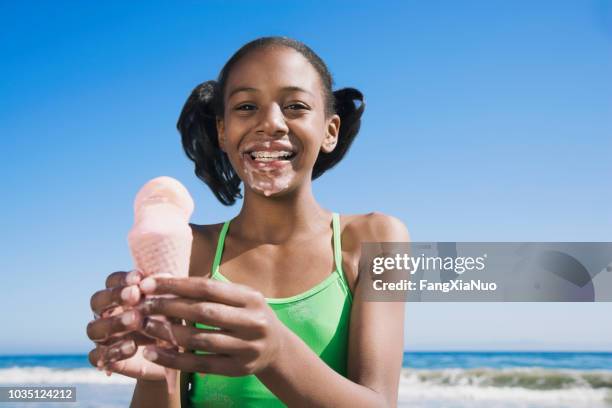 afrikanisches mädchen mit schmelzendem eis - girl eating messy ice cream cone stock-fotos und bilder