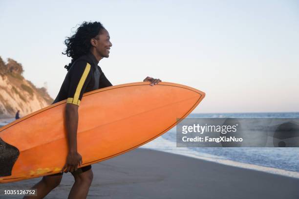 afrikanerin mit surfbrett - beach hold surfboard stock-fotos und bilder
