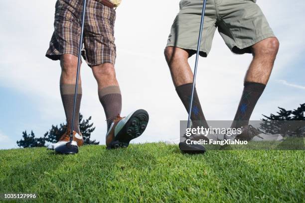 multi-ethnic men on golf course stretching - bent golf club stock pictures, royalty-free photos & images