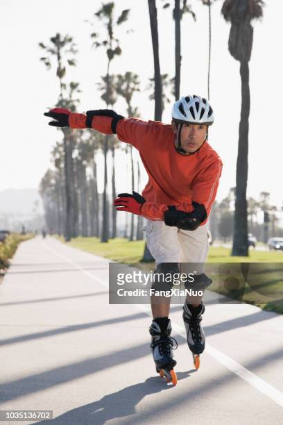 patines de hombre asiático - inline skating fotografías e imágenes de stock