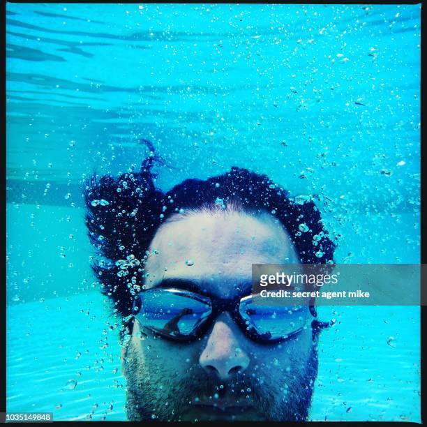 underwater man in pool - cannonball diving stock-fotos und bilder