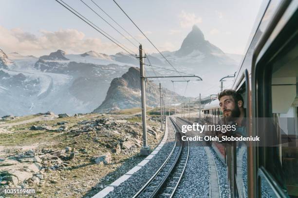 mann, blick aus dem fenster auf den zug in der nähe von matterhorn - bart zug stock-fotos und bilder