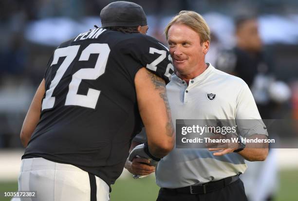 Head coach Jon Gruden of the Oakland Raiders shakes the hand of his player Donald Penn during pregame warm ups prior to the start of the game against...