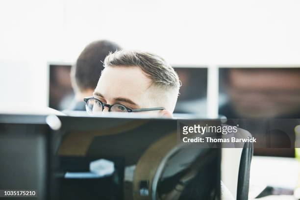 portrait of engineer looking at computer monitor while coding in computer lab - staff bonding stock pictures, royalty-free photos & images
