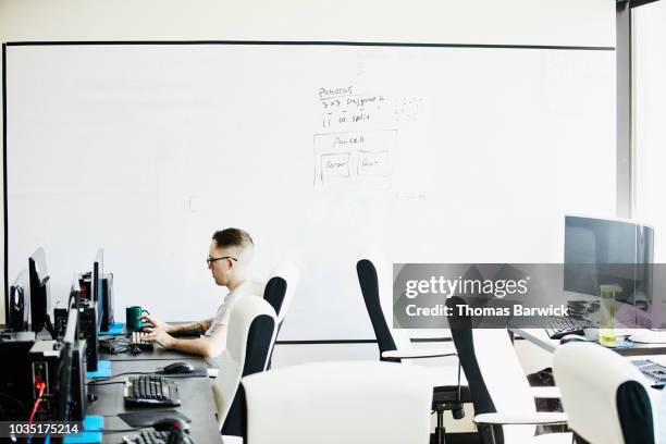 engineer coding at desk in empty computer lab - digital native stock pictures, royalty-free photos & images