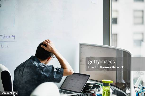 engineer scratching head while looking at calendar on computer monitor in virtual reality lab - ict problems stock-fotos und bilder